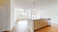 This 730 square foot apartment in Orlando, FL offers a harmonious blend of modern design and practical living. The open-concept floor plan maximizes space efficiency, seamlessly connecting the living area, dining space, and kitchen. The heart of the home is the contemporary kitchen, boasting sleek light wood cabinetry, stainless steel appliances, and a spacious island with a granite countertop, perfect for casual dining or food preparation.

Natural light floods the space through large windows and a glass door, which likely leads to a balcony or patio. The living area features warm wood-look flooring and a ceiling fan for comfort. The bedroom, measuring 140 square feet, includes plush carpeting and a walk-in closet with wire shelving for ample storage.

The bathroom is designed with functionality in mind, featuring a combination tub-shower, modern vanity, and wood-look flooring that complements the main living areas. Throughout the apartment, recessed lighting and pendant fixtures provide layered illumination.

This well-designed space offers a perfect balance of style and functionality, ideal for those seeking a cozy yet contemporary living environment in the heart of Orlando.