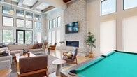Located at 5 Tree Farm Drive in Carbondale, Colorado, this thoughtfully designed single-floor amenity space offers an impressive blend of modern aesthetics and functional gathering areas set against a scenic mountain backdrop.

The expansive kitchen and living room serves as the heart of the space, anchored by a dramatic floor-to-ceiling stacked stone fireplace with a mounted flat-screen TV above a sleek linear hearth. Soaring ceilings with exposed wood beams add warmth and architectural character, while an abundance of floor-to-ceiling windows and clerestory windows flood the interior with natural light. Light hardwood flooring runs throughout, complementing the contemporary furnishings and a billiard table that adds a recreational touch. The open kitchen features a substantial waterfall-edge marble island with seating for several guests, warm wood cabinetry, stainless steel appliances, open shelving, and a cluster of globe pendant lights overhead.

The dedicated exercise room is generously sized and fully outfitted with cardio equipment including treadmills and ellipticals, free weights, cable machines, weight benches, and floor-to-ceiling mirrors. Bold teal accent walls and bright overhead lighting create an energizing atmosphere, and a compact refreshment station adds convenience.

Large glass doors open directly to an outdoor pool and patio area, framing sweeping views of the surrounding Colorado mountains.