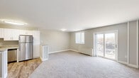 Located at 3801 Conshohocken Ave in Philadelphia, PA, this two-bedroom, one-bathroom residence offers a well-designed single-floor layout with a clean, modern aesthetic throughout. The open-concept kitchen and living area serves as the heart of the home, where the kitchen impresses with crisp white shaker cabinetry, granite countertops, a peninsula island, and a full suite of stainless steel appliances including a gas range, microwave, dishwasher, and refrigerator. Wood-look flooring anchors the kitchen, while plush carpeting extends throughout the living area and bedrooms, adding warmth and comfort. The spacious living room is bathed in natural light from large windows and sliding glass doors that open onto a private balcony, offering pleasant outdoor views. The primary bedroom is generously sized, featuring dual closets with paneled bi-fold doors and a bright window. The second bedroom is equally well-proportioned with its own window and wall heater. The full bathroom features classic white subway tile surrounding the bathtub and wood-look flooring for a timeless finish. Two closets provide ample storage throughout the unit. Neutral gray tones and white trim create a bright, cohesive look across the entire residence.