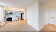 This 540 square foot apartment in Durham, NC offers a thoughtfully designed living space on a single floor. The modern kitchen is a highlight, equipped with sleek white cabinetry, stainless steel appliances, and a subway tile backsplash. It features a range, microwave, dishwasher, and refrigerator, all seamlessly integrated into the compact layout.

The living area is distinguished by its airy feel, enhanced by light wood flooring and a striking accent wall in sage green. Large windows invite natural light, creating a sense of openness. The space is versatile, easily accommodating both living and dining functions.

The bathroom boasts a contemporary design with a spacious walk-in shower, featuring sliding glass doors and white tiling. Adjacent to the bathroom, a closet area provides ample storage.

Two hallways efficiently connect the various spaces, maintaining a flow throughout the apartment. The inclusion of a balcony offers an outdoor extension to the living space, perfect for enjoying fresh air or city views.

Overall, this apartment combines modern aesthetics with practical living, making excellent use of its 540 square feet through intelligent space planning and contemporary finishes.