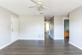 Located at 100 Lochlyn Pl in Warner Robins, Georgia, this single-story home offers a practical and well-organized layout across multiple rooms. The living areas are finished with rich, dark hardwood-style flooring that runs throughout the main spaces, lending a cohesive and polished look. Each room features ceiling fans with light fixtures, and textured ceilings add a classic residential character throughout.

The kitchen is equipped with warm-toned wood cabinetry offering generous storage, a white electric range, a built-in microwave, a refrigerator, a dishwasher, and a double sink — providing a fully functional cooking space. Natural light filters in through windows, brightening the neutral-toned walls.

The bedrooms are carpeted in a neutral tone, offering comfort underfoot, and each room benefits from windows that allow natural light in. The spacious primary bedroom includes access to a closet, with a ceiling fan overhead. Additional bedrooms are similarly sized and well-lit.

The home includes two bathrooms, each featuring wood-toned vanity cabinetry, hardwood-style flooring, and clean white fixtures. One bathroom includes a tub/shower combination. A hallway connects the bedrooms and bathrooms, providing an efficient and straightforward floor plan suited for everyday living.