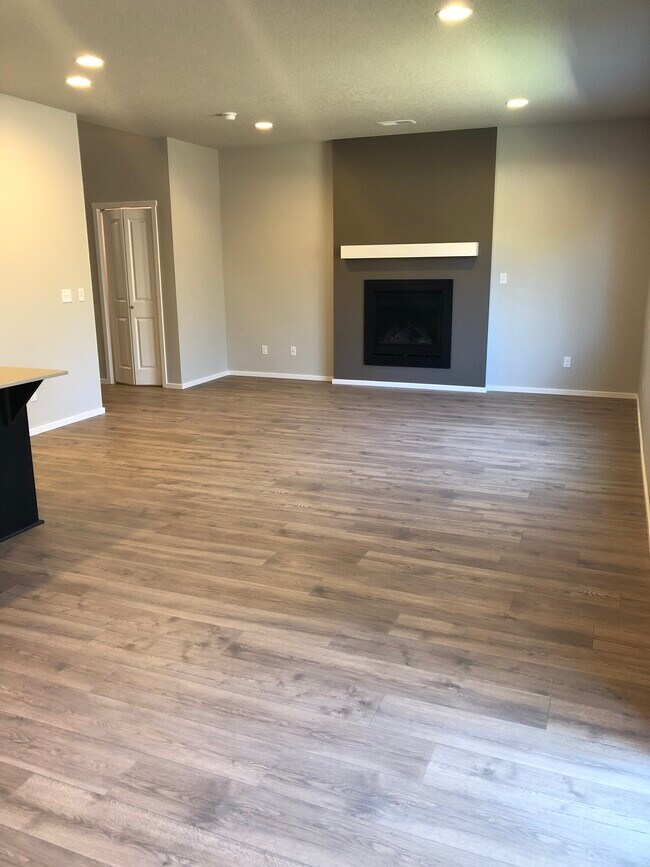 Salón de concepto abierto con chimenea - 20556 SE Evian Ave