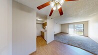 Located at 1260 E Guinevere St in Springfield, MO, this single-floor, 2-bedroom, 2-bathroom home offers a practical and well-organized layout. The carpeted living room is a welcoming central space, featuring a ceiling fan, textured ceiling, and a sliding glass door with vertical blinds that opens to an outdoor area and allows natural light to fill the room. Adjacent to the living room, the dining area transitions into a galley-style kitchen finished with warm wood cabinetry, light countertops, a double-basin sink, and durable hardwood-style flooring — providing ample storage and workspace. Both bedrooms are carpeted and include ceiling fans and windows with blinds, offering natural light and outdoor views. The primary bedroom features multiple windows, enhancing its sense of openness. Each of the two full bathrooms is equipped with a tub-shower combination, a wood-tone vanity with storage drawers, and tile flooring. A hallway connects the main living spaces to the bedrooms and bathrooms, with three closets providing generous storage throughout. A dedicated utility room adds further practicality. Textured ceilings and warm wood trim accents are consistent design elements found throughout the home.