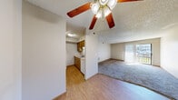 Located at 1260 E Guinevere St in Springfield, MO, this single-floor, 2-bedroom, 2-bathroom home offers a practical and well-organized layout. The carpeted living room is a welcoming central space, featuring a ceiling fan, textured ceiling, and a sliding glass door with vertical blinds that opens to an outdoor area and allows natural light to fill the room. Adjacent to the living room, the dining area transitions into a galley-style kitchen finished with warm wood cabinetry, light countertops, a double-basin sink, and durable hardwood-style flooring — providing ample storage and workspace. Both bedrooms are carpeted and include ceiling fans and windows with blinds, offering natural light and outdoor views. The primary bedroom features multiple windows, enhancing its sense of openness. Each of the two full bathrooms is equipped with a tub-shower combination, a wood-tone vanity with storage drawers, and tile flooring. A hallway connects the main living spaces to the bedrooms and bathrooms, with three closets providing generous storage throughout. A dedicated utility room adds further practicality. Textured ceilings and warm wood trim accents are consistent design elements found throughout the home.