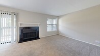 Located at 4334 E 66th St S in Tulsa, Oklahoma, this one-bedroom, three-bathroom residence offers a well-organized single-floor layout designed for comfortable everyday living. The open living room is a standout space, anchored by a classic black-tiled fireplace with a white mantel and framed by windows that invite natural light. Soft carpet underfoot extends throughout the living area and bedroom, creating a warm, cohesive feel. The galley-style kitchen is efficiently designed with white shaker cabinetry, white quartz countertops, a stainless steel sink, subway tile backsplash, and black appliances including a range, dishwasher, microwave, and refrigerator. Wood-look flooring runs through the kitchen and connects to the entrance corridor. A peninsula counter provides a natural transition between the kitchen and living room. The spacious primary bedroom features a ceiling fan, a dedicated closet, and direct access to a private bathroom. The bathrooms are finished with wood-look tile flooring, white vanities with quartz countertops, and brushed nickel hardware. One bathroom includes a tub-shower combination with white tile surround. A dedicated entrance and closet round out this thoughtfully laid-out home.