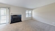 Located at 4334 E 66th St S in Tulsa, Oklahoma, this one-bedroom, three-bathroom residence offers a well-organized single-floor layout designed for comfortable everyday living. The open living room is a standout space, anchored by a classic black-tiled fireplace with a white mantel and framed by windows that invite natural light. Soft carpet underfoot extends throughout the living area and bedroom, creating a warm, cohesive feel. The galley-style kitchen is efficiently designed with white shaker cabinetry, white quartz countertops, a stainless steel sink, subway tile backsplash, and black appliances including a range, dishwasher, microwave, and refrigerator. Wood-look flooring runs through the kitchen and connects to the entrance corridor. A peninsula counter provides a natural transition between the kitchen and living room. The spacious primary bedroom features a ceiling fan, a dedicated closet, and direct access to a private bathroom. The bathrooms are finished with wood-look tile flooring, white vanities with quartz countertops, and brushed nickel hardware. One bathroom includes a tub-shower combination with white tile surround. A dedicated entrance and closet round out this thoughtfully laid-out home.