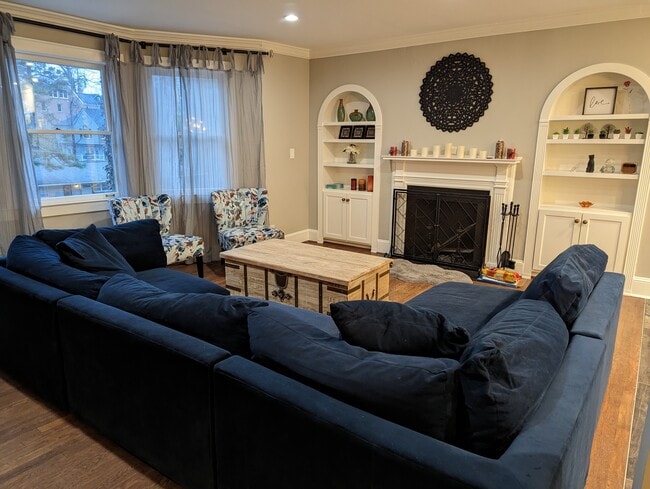 Main living room with comfy sofa and wood burning fireplace - 1185 Rosedale Rd NE