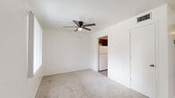 Located at 2230 E Fort Lowell Rd in Tucson, Arizona, this single-floor, three-bedroom, one-bathroom home offers a straightforward and practical layout. The living room serves as the central gathering space, featuring neutral-toned carpet, a ceiling fan with light fixture, and windows with vertical blinds that allow natural light to filter in. The room flows conveniently toward the kitchen and the hallway leading to the bedrooms.

The kitchen is well-equipped with dark wood cabinetry extending to the upper walls for generous storage, light-colored countertops, a double-basin stainless steel sink, an electric range, and a refrigerator. Wood-look vinyl flooring ties the space together cleanly.

The three bedrooms are carpeted and finished in crisp white, each offering a quiet and functional retreat. One bedroom features exposed concrete block walls and a window with natural light, while others include ceiling vents for climate control. The primary bedroom provides a comfortable footprint with access to a closet.

The bathroom is finished with wood-look vinyl flooring, a single-sink vanity with dark cabinetry, a full tub-shower combination, and clean white walls — providing a tidy and efficient design. A connecting hallway links the main living areas to the bedrooms and bathroom, completing this compact yet well-organized home.