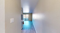 Located at 4816 McMahon Blvd NW in Albuquerque, New Mexico, this one-bedroom, two-bathroom residence offers a well-organized single-floor layout designed for comfortable everyday living. The open-concept living and kitchen area forms the heart of the home, where light wood-style flooring flows throughout, creating a bright and cohesive aesthetic. The kitchen features a peninsula-style breakfast bar with neutral countertops, stainless steel appliances including a refrigerator and gas range, white cabinetry, and an overhead ventilation hood — providing both functionality and style. Built-in open shelving adds additional storage near the kitchen. The living area is generously proportioned, bathed in natural light, and opens directly onto a private balcony through sliding glass doors, offering outdoor views of the surrounding community. The bedroom is a comfortable, well-lit space with a mirrored sliding closet and a window that brings in natural light. Two full bathrooms serve the unit — one featuring a tiled tub-shower combination, and the other with a vanity, mirror, and hardwood-style flooring. A hallway connects the spaces efficiently, completing this clean, move-in-ready home.