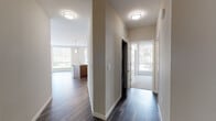 This single-floor residence at 505 Lincoln Ave in San Jose, California, offers a thoughtfully designed layout with modern finishes and a clean, contemporary aesthetic throughout. Dark hardwood-style flooring runs through the main living areas, providing a warm contrast against the neutral, light-toned walls and crisp white trim.

The open-concept living and kitchen area serves as the heart of the home, featuring large windows with roller shades that invite generous natural light and views of surrounding greenery. The kitchen is well-appointed with white upper cabinetry, rich wood-toned lower cabinets, a tile backsplash, stainless steel appliances, and a peninsula with granite countertops and pendant lighting overhead — ideal for both cooking and casual dining.

The bedrooms are carpeted for comfort, each receiving ample natural light through sizable windows. Wall-mounted mini-split HVAC units provide individualized climate control. The bathrooms are finished with wood-grain cabinetry, wide vanity mirrors, and full soaking tubs with shower combinations. A second, more compact bathroom echoes the same clean design. A hallway connects the private areas to the main living space, maintaining a logical and efficient flow throughout the residence.