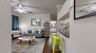 Located in Austin, TX, this generously sized one-bedroom, one-bathroom residence offers a well-designed layout across a single floor. The open-concept living and kitchen area is anchored by rich hardwood-style flooring, crown molding, and a ceiling fan, creating a bright and welcoming atmosphere. Sliding glass doors lead to a private covered balcony overlooking mature trees, providing a peaceful outdoor retreat with wrought iron railing.

The kitchen is well-appointed with stainless steel appliances, including a refrigerator, range, and built-in microwave, complemented by white cabinetry, dark granite-style countertops, and a double-basin sink. The space flows seamlessly into the living area, making it ideal for both everyday living and entertaining.

The spacious bedroom features plush carpeting, a ceiling fan, and a large window that brings in natural light. The full bathroom includes a granite-topped vanity with white cabinetry, a large mirror, and a shower-tub combination. A dedicated closet provides ample storage, and a separate laundry area with a full-size washer and wire shelving adds everyday convenience. Crown molding throughout lends a refined, cohesive finish to the entire residence.