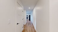 Located at 555 Court St in Auburn, Maine, this thoughtfully designed single-floor unit offers a clean, modern aesthetic with high-quality finishes throughout. Light hardwood-style flooring runs through the main living areas and hallways, while plush carpeting adds comfort to the bedrooms.

The kitchen is a standout feature, boasting white shaker cabinetry, granite countertops, a shiplap-accented island with a second sink, and a full suite of stainless steel appliances including a refrigerator, range, microwave, and dishwasher. Natural light flows in through a window above the main sink, brightening the space.

The bedrooms are generously sized, carpeted, and include baseboard heating and windows that bring in natural light. One bedroom features a walk-in closet with built-in shelving. The living area connects directly to an outdoor deck through a glass-paneled door, complemented by a wall-mounted mini-split unit for climate control and views of the surrounding neighborhood.

A dedicated in-unit laundry area houses a full-size washer and dryer with overhead wire shelving for added storage. A bright hallway with recessed lighting connects all areas of the unit seamlessly. The overall ambiance is fresh, clean, and move-in ready.