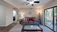 Located at 1620 Woods Rd in Winston-Salem, NC, this single-floor, 3-bedroom, 2-bathroom residence offers a well-organized and comfortable layout. The living room serves as the heart of the home, featuring a wood-burning fireplace, a ceiling fan, and a sliding glass door that opens to a private balcony with wooded views, flooding the space with natural light. Carpeted flooring adds warmth to the living area, which flows conveniently into the kitchen and dining room. The kitchen is equipped with white cabinetry, granite-look countertops, and black appliances, providing ample storage and prep space. The adjacent dining area features wood-look flooring, wainscoting detail, and easy access to the front entry. The primary bedroom offers comfortable proportions, carpeted flooring, and a ceiling fan, accompanied by a walk-in closet with dual hanging rods and shelving. The additional bedrooms are well-sized with neutral tones and carpeted floors. Both bathrooms include tub-shower combinations with tiled surrounds. A hallway connects the private sleeping quarters, completing this efficiently designed and move-in-ready residence.