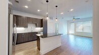 This contemporary apartment, located at 2626 Throckmorton St in Dallas, TX, offers 930 square feet of meticulously designed living space. The single-story layout comprises two bedrooms, including a spacious 160 sq ft primary bedroom, and two full bathrooms. The open-concept design seamlessly integrates the kitchen and living areas, creating a fluid and spacious atmosphere.

The kitchen is a chef's delight, boasting sleek wood-grain cabinetry, stainless steel appliances, and a stylish hexagonal tile backsplash. A central island with a built-in sink enhances functionality and provides additional counter space. The living area features warm wood-look flooring and large windows that flood the space with natural light.

Both bedrooms offer plush carpeting and ample closet space, with the primary bedroom boasting an en-suite bathroom. The bathrooms are fitted with modern fixtures, including double vanities with ample storage and a shower-tub combination. Throughout the apartment, recessed lighting and ceiling fans add both ambiance and comfort.

The unit's neutral color palette and clean lines create a versatile canvas for various decorating styles. With its thoughtful design and high-end finishes, this apartment offers a perfect blend of comfort and urban sophistication.