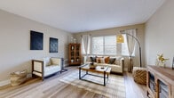 Located at 12 Kings Grant Rd in Holly Hill, Florida, this thoughtfully designed 2-bedroom, 2-bathroom single-floor home offers a comfortable and stylish living experience. Light wood-style flooring flows throughout, tying the space together with a cohesive, warm aesthetic.

The living room is bright and inviting, featuring large windows with horizontal blinds that welcome natural light, neutral walls, and a relaxed layout ideal for both entertaining and everyday living. Adjacent hallways connect the space efficiently, leading to the dining room — a charming nook highlighted by a skylight and a distinctive arched pass-through window that adds architectural character.

The kitchen is well-equipped with white shaker-style cabinetry, light stone countertops, and a full suite of stainless steel appliances, offering both functionality and a clean, modern look.

The primary bedroom is a tranquil retreat with ample room, natural light from a window with sheer curtains, and light wood flooring. The second bedroom mirrors the serene aesthetic. Each bathroom offers its own configuration — one featuring a tub-shower combo and the other a walk-in shower — both finished in clean, neutral tones. A dedicated closet provides practical storage, completing this efficiently laid-out and attractively finished home.
