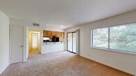 Located at 1811 Sibley Rd in Augusta, Georgia, this single-floor residence offers a well-organized layout with comfortable, functional living spaces throughout. The open-concept living and dining area is finished with plush carpeting and features a textured ceiling, a large sliding glass door leading to a private balcony, and a side window that frames lush greenery, filling the space with natural light. The kitchen is designed in a galley style and is equipped with warm wood cabinetry, dark granite countertops, black appliances including a range and refrigerator, and light hardwood-style flooring. A pass-through counter connects the kitchen to the living area, enhancing the open feel. The bedrooms are carpeted and each include a ceiling fan with integrated lighting and windows that allow in natural light, creating a comfortable and airy atmosphere. The bathroom is clean and efficiently laid out, featuring a tub-shower combination, a vanity with dark countertop, and hardwood-style flooring that complements the rest of the unit. Throughout the residence, neutral tones and consistent finishes create a cohesive and inviting ambiance, while the balcony access and multiple windows ensure a strong connection to the surrounding outdoor environment.