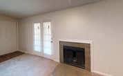 Located at 9109 Saddlehorn Dr in Fort Worth, TX, this single-story home offers a straightforward, functional layout across several well-defined living spaces. The living room serves as a central gathering area, highlighted by a tile-surround fireplace with a classic white mantel and a set of French doors that allow natural light to fill the room. Soft carpet underfoot and neutral walls create a clean, versatile backdrop throughout.

The galley-style kitchen is equipped with white cabinetry, dark laminate countertops, wood-look flooring, and black appliances including a refrigerator and electric range, providing an efficient and organized cooking space.

The bedrooms are carpeted and feature ceiling fans, with natural light provided by windows dressed with blinds. Multiple bedrooms include walk-in closets, offering notable storage capacity. The rooms maintain a neutral palette that adapts easily to various furnishing styles.

Two bathrooms serve the home, each featuring white vanity cabinetry, dark granite-style countertops, a single sink, and a tub-shower combination with tiled surrounds. Wood-look flooring in the bathrooms complements the fixtures throughout. Textured ceilings are consistent across the home, adding a classic residential character to each room.
