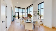 Located at 35 E Hubbard Ave in the heart of Columbus, Ohio, this sophisticated 2-bedroom, 1-bathroom residence offers a thoughtfully designed open-concept layout with impressive architectural details. The combined kitchen and living area is the centerpiece of the home, distinguished by dramatic floor-to-ceiling windows that flood the space with natural light and offer sweeping views of the Columbus skyline. Soaring ceilings amplify the sense of openness, while light-toned hardwood floors run throughout.

The kitchen is a standout, featuring custom grey cabinetry, a herringbone tile backsplash, quartz countertops, stainless steel appliances, and a large central island with bar seating, illuminated by globe pendant lights. The open living and dining area seamlessly connects to the kitchen, creating an ideal space for entertaining.

Both bedrooms are well-proportioned, bathed in natural light through large black-framed windows with urban views, and include dedicated closet space with built-in shelving. The bathroom is elegantly appointed with marble-style tile flooring, a glass-enclosed walk-in shower, and a sleek double vanity with illuminated mirrors. A hallway connects all rooms with clean, modern transitions throughout.