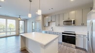 Located at 257 Indian Lake Blvd in Hendersonville, Tennessee, this thoughtfully designed 2-bedroom, 2-bathroom residence offers a comfortable and modern living experience on a single floor. The open-concept kitchen and living area serves as the heart of the home, featuring gray shaker-style cabinetry, a classic white subway tile backsplash, stainless steel appliances, and a spacious kitchen island with a clean white countertop illuminated by stylish pendant lighting. Wood-look flooring flows throughout the main living areas, adding warmth and continuity. The bright and expansive living room benefits from large windows and glass doors that invite generous natural light and provide outdoor views, complemented by dual ceiling fans overhead. The generously sized primary bedroom features plush carpeting, a ceiling fan, and direct access to a dedicated closet and a private en-suite bathroom complete with a dual-sink vanity, gray cabinetry, and a walk-in glass-enclosed shower. The second bedroom is equally comfortable with soft carpet and a bright window. The second bathroom features a tiled tub-shower combo, wood-look flooring, and a single-sink vanity with matching cabinetry and matte black hardware. Two closets provide ample storage throughout the residence.