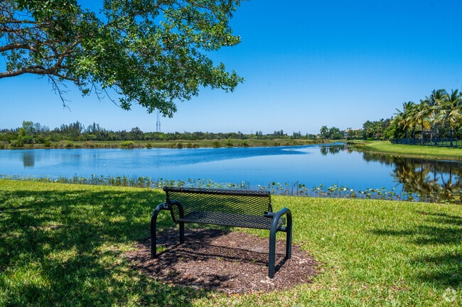 Bench with tree shade overlooking Swan Lake and homes.