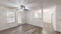 Located at 100 Camellia Ln in Stonecrest, GA, this single-story, one-bedroom, one-bathroom home offers a thoughtfully organized layout across a comfortable footprint. The living room is bright and welcoming, featuring wood-style flooring, a ceiling fan with light fixture, a textured ceiling, and multiple windows with blinds that invite natural light. A door from the living area leads to an outdoor space, adding to the open, airy feel of the room. A pass-through window connects the living area to the kitchen, enhancing the open flow of the home. The galley-style kitchen is well-equipped with white cabinetry, light countertops, black appliances including a range and refrigerator, a dishwasher, and a stainless steel sink. The bedroom offers plush carpeting, a large window with views of surrounding greenery, and direct access to a dedicated closet. The bathroom features a full tub-shower combination with white tile surround and chrome fixtures. A dedicated laundry room houses side-by-side washer and dryer units on wood-style flooring. Throughout the home, neutral tones and clean finishes create a consistent, move-in-ready aesthetic.