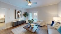 This single-floor residence on Gold Crest Drive in Greensboro, North Carolina, offers a thoughtfully designed open-concept layout with contemporary finishes throughout. The kitchen serves as a central focal point, featuring white shaker cabinetry, stainless steel appliances, glass-front upper cabinets, and a granite-topped island with bar seating — an ideal space for both meal preparation and casual dining. Adjacent to the kitchen, the dedicated dining area accommodates a full table and is accented by crown molding and warm wood-tone flooring that extends throughout the main living areas.

The living room is bright and welcoming, with a ceiling fan, access to a private outdoor balcony through French doors, and ample space for comfortable furnishings. The bedrooms are carpeted and each include ceiling fans and natural light from well-positioned windows. The primary suite features a spacious walk-in closet outfitted with multi-tier wire shelving systems. Bathrooms are finished with granite-topped vanities, framed mirrors, and the primary bath includes a large glass-enclosed walk-in shower. Crown molding and recessed lighting are consistent throughout, contributing to a polished, cohesive aesthetic across the entire residence.
