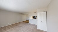 Located at 700 S Fourth St in Waco, TX, this one-bedroom, one-bathroom unit offers a practical and comfortable single-floor layout. The living room serves as the heart of the space, featuring plush carpeting, a classic fireplace with a white mantle and dark tile surround, and neutral walls that create a warm, inviting atmosphere. A textured ceiling runs throughout, adding a consistent design element across the home. The living area flows into a defined dining space, separated by a half-wall pass-through that connects to the kitchen, which includes white cabinetry and a built-in countertop bar. Wood-look flooring in the entrance and kitchen areas provides a clean contrast to the carpeted rooms. The bedroom is a comfortable, well-proportioned room featuring a ceiling fan with light fixture, a window with blinds that allows natural light to filter in, and a dedicated closet with louvered doors for ample storage. The bathroom includes wood-look flooring, a full tub and shower combination with neutral tile surround, and a vanity with a light countertop. Overall, the unit presents a clean, neutral palette throughout, making it an easy canvas for personalization.
