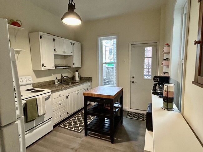 Kitchen with bucher block island, microwave, coffee maker and storage - 1425 N Lawrence St