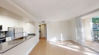 Located in Miami Lakes, FL, this efficient one-bedroom, one-bathroom residence offers a well-designed layout across a single floor. The open living area is bathed in natural light, showcasing light wood-toned flooring and clean white walls with crown molding that lend a bright, airy feel throughout.

The kitchen is accessible via a pass-through opening to the living area, creating a connected and functional flow. It features stainless steel appliances — including a refrigerator, range, and microwave — white cabinetry offering ample storage, a dark countertop, and a stainless steel sink. A textured ceiling and recessed lighting complete the kitchen's practical design.

The bedroom is a comfortable, well-proportioned space with a ceiling fan, a window overlooking lush greenery, and continued wood-toned flooring. A hallway connects the bedroom to the rest of the unit, with a closet featuring louvered bifold doors providing convenient storage.

The bathroom is clean and functional, outfitted with a white vanity with a framed mirror, a tiled shower-tub combination, and matching light flooring. Throughout the unit, consistent neutral tones and natural light create a cohesive, welcoming ambiance suited to everyday living in the heart of Miami Lakes.