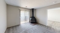 Located at 2827 S Emporia St in Wichita, Kansas, this single-floor unit offers four bedrooms, two full bathrooms, and a thoughtfully arranged layout that maximizes its footprint. The living area serves as the heart of the home, highlighted by a striking freestanding wood-burning stove set on a brick hearth and a sliding glass door fitted with vertical blinds that fill the room with natural light and provide access to an outdoor area. Soft, neutral carpet runs throughout the living space and all four bedrooms, creating a cohesive and comfortable feel. The generously sized primary bedroom benefits from natural light through a window with blinds, while the additional bedrooms are similarly appointed, with at least one featuring a bi-fold closet. A dedicated closet provides additional storage. The galley-style kitchen is well-equipped with warm wood cabinetry, ample counter space, a double-basin sink, an electric range, a refrigerator, a dishwasher, and durable wood-look flooring that extends into the adjoining hallway. A textured ceiling is consistent throughout the unit. The two bathrooms each include a full tub and shower combination with clean white surrounds and overhead cabinetry for storage.