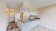 Located at 1363 Hideaway Woods Dr in Westerville, Ohio, this single-floor residence offers a well-designed, open layout that maximizes comfort and functionality. The kitchen serves as a central hub, featuring a peninsula with dark granite-look countertops, white cabinetry, recessed lighting set within a raised ceiling detail, and white appliances including a refrigerator, range, and microwave. The peninsula provides a natural transition into the adjoining living and dining areas, which are finished with plush carpet and neutral wall tones that create a warm, inviting atmosphere. A sliding glass door in the living area floods the space with natural light and provides outdoor views. Wood-look luxury vinyl plank flooring runs through the entry hallway and connects the main living spaces seamlessly. The bedrooms are generously proportioned, each carpeted and brightened by large windows that bring in ample daylight. The bathroom is finished with wood-look tile flooring and includes a soaking tub with a curved shower rod. Built-in shelving adds practical storage. Throughout the home, the clean, neutral palette and consistent finishes contribute to a cohesive, move-in-ready feel suited for comfortable everyday living.