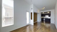 Located in Denver's vibrant Central Park neighborhood, this single-floor residence at 10400 East 29th Drive offers a sleek, modern design with an open-concept layout that maximizes both space and functionality. Rich hardwood flooring extends throughout the main living area, providing warmth and continuity across the floor plan.

The living space is characterized by soaring vaulted ceilings that create an airy, expansive atmosphere, complemented by large windows that flood the interior with abundant natural light. Crisp white walls enhance the brightness of the space, while an accent wall in a warm earth tone adds depth and visual interest to the design.

A private entry door with a glass panel leads directly into the main living area, offering a welcoming transition into the home. The open layout flows seamlessly into the kitchen, which features dark cabinetry, stainless steel appliances, a decorative tile backsplash, and track lighting overhead — a practical yet stylish space for cooking and entertaining.

The overall ambiance is clean, contemporary, and well-lit, with thoughtful design details that balance modern aesthetics with everyday comfort. The single-floor layout ensures easy accessibility and a cohesive living experience throughout.