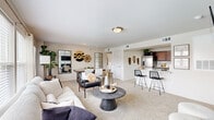 This single-story residence in Oklahoma City, OK offers a thoughtfully designed open-concept floor plan accommodating two bedrooms and two full bathrooms. The living and kitchen areas flow seamlessly together, creating a versatile space ideal for both everyday living and entertaining. The living room features plush carpet flooring, large windows that invite abundant natural light, and a sleek built-in electric fireplace serving as a striking focal point beneath a wall-mounted TV display. A separate seating area with direct outdoor views adds additional functional living space.

The kitchen is equipped with rich dark cabinetry, stainless steel appliances including a refrigerator, a marble-look countertop, and a breakfast bar with seating, connecting directly to the dining area for convenient entertaining.

The primary bedroom is a comfortable retreat, featuring carpet flooring, a ceiling fan, and a walk-in closet. The second bedroom also offers carpet flooring, natural light from windows, and a ceiling fan. Both bathrooms are finished with dark wood cabinetry, marble-look countertops, large vanity mirrors, and tub-shower combinations with tile surrounds. A connecting hallway ties all rooms together efficiently, contributing to the home's cohesive and functional layout.