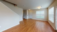 This two-story residence offers a thoughtfully designed layout across two floors, providing comfortable separation between living and private spaces. The main level features a spacious living area with warm hardwood-style flooring, a ceiling fan, and a door leading to an outdoor area, allowing natural light to fill the room. The galley-style kitchen is well-equipped with rich dark cabinetry, granite-style countertops, a tile backsplash, stainless steel appliances including an electric range, microwave, refrigerator, and dishwasher, along with a dedicated pantry for additional storage. A convenient half bathroom on this level features hardwood-style flooring and granite-topped vanity cabinetry. The upper level houses two generously sized bedrooms, each with plush carpeting and ceiling fans. The bedrooms are served by two full bathrooms, each featuring tiled shower-tub combinations, granite-topped vanities with dark wood cabinetry, and hardwood-style flooring. Spacious walk-in closets with built-in shelving and hanging rods provide ample storage. A dedicated laundry area with washer and dryer hookups adds everyday convenience throughout this well-appointed home.
