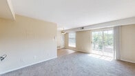 Located on Naylor Road SE in Washington, DC, this one-bedroom unit offers a practical and comfortable layout across a single floor. The living room is generously proportioned, featuring neutral beige walls, plush wall-to-wall carpeting, and large windows and a sliding glass door that flood the space with natural light. The sliding door opens to a private balcony with striking views of a community swimming pool and a lush, tree-lined landscape stretching into the distance — a standout feature of this unit.

The galley-style kitchen is well-appointed with warm wood cabinetry, granite-style countertops, and light hardwood-style flooring. It is equipped with stainless steel appliances including a gas range, built-in microwave, and refrigerator, offering ample storage and counter space for everyday cooking.

The bedroom provides a comfortable retreat with soft carpeting, neutral tones, and a wide double sliding-door closet offering substantial storage. The room is bright and well-proportioned, with enough space to accommodate a full bedroom suite.

Throughout the unit, the clean, understated design with consistent neutral tones creates a calm and cohesive atmosphere, making it a functional and inviting home in Southeast Washington, DC.