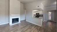 This single-floor residence offers a thoughtfully designed layout with a blend of modern finishes and functional living spaces throughout. The living area serves as the heart of the home, featuring a classic white-mantled fireplace and durable wood-look flooring that flows seamlessly into the adjoining areas. A large window invites natural light, creating a bright and welcoming atmosphere.

The kitchen is well-equipped and efficiently laid out, with white shaker-style cabinetry, granite-look countertops, a mosaic tile backsplash, and stainless steel appliances including a refrigerator, electric range, microwave, and dishwasher. A pass-through counter connects the kitchen to the main living space, enhancing the open feel.

The bedrooms are finished with plush wall-to-wall carpeting, ceiling fans with light kits, and windows fitted with blinds that allow for natural light and privacy. The primary bedroom includes a private en-suite bathroom and an additional walk-in closet area. The bathrooms are appointed with granite-topped vanities, white cabinetry with brushed nickel hardware, and tiled shower-tub combinations. Wood-look flooring in the bathrooms adds a cohesive, contemporary touch throughout the home.