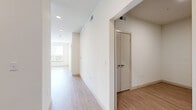 This single-floor residence in Round Rock, Texas offers a clean, modern design with a thoughtfully arranged layout encompassing two bedrooms, one bathroom, and a combined kitchen and living area. Light wood-style flooring runs throughout the main living spaces and hallways, lending a bright and cohesive aesthetic, while plush carpeting adds comfort to both bedrooms. The kitchen is well-appointed with warm wood-toned cabinetry, a teal glass tile backsplash, stone-look countertops, and a full suite of stainless steel appliances, including a refrigerator, range, and built-in microwave. The open connection to the living area enhances the sense of space and flow. The primary bedroom is generously sized, featuring a ceiling fan and a large window that invites natural light and outdoor views. The second bedroom also offers carpeted flooring and a bright, open feel. The bathroom includes a full tiled tub-and-shower combination with built-in shelving, complemented by wood-style flooring. A dedicated closet with built-in shelving provides organized storage. Throughout the residence, crisp white walls, recessed lighting, and consistent finishes create a clean, modern ambiance suited to comfortable everyday living.