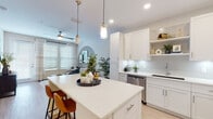 Located at 375 Summer Cypress Cv in Longwood, Florida, this single-story home offers a thoughtfully designed open-concept layout with modern finishes and a bright, airy aesthetic throughout. Light wood-tone flooring runs continuously across the space, complementing the neutral color palette.

The kitchen is a standout feature, showcasing crisp white shaker cabinetry, subway tile backsplash with under-cabinet lighting, stainless steel appliances including a French door refrigerator and range, and a generous center island with quartz countertops and bar seating. Pendant lighting adds a refined touch overhead.

The open living area flows seamlessly from the kitchen and is highlighted by a distinctive arched accent wall, ceiling fan, and large windows with French doors that invite abundant natural light. A dedicated home office features a bold navy accent wall and double closet doors, offering versatile functionality.

Both bedrooms are well-proportioned, each with large windows dressed in blinds and sheer curtains that fill the rooms with light. The bathroom presents a clean, contemporary design with a white floating vanity, quartz countertop, tub-shower combination, and light wood-tone flooring. The overall ambiance is modern, welcoming, and move-in ready.