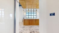 Located at 303 South Federal Highway in Hollywood, Florida, this generously sized amenity floor at the Bread Building delivers a sophisticated blend of modern design and resort-style functionality. The interior is anchored by striking large-format marble tile flooring that flows throughout the open-plan spaces, complemented by soaring ceilings and floor-to-ceiling grid-pane windows that flood the interior with natural light and frame sweeping views of the South Florida skyline.

At the heart of the space is a curved, warm-wood reception island topped with a polished stone countertop, accented by brass pendant lighting and a slatted wood ceiling detail above. A dedicated game area features a pool table and wall-mounted display beneath bold teal-painted exposed structural elements, adding a vibrant, energetic accent to the otherwise crisp white palette. The conference and dining room offers a refined, intimate setting with blue-toned walls, velvet seating, and curated wall art.

The expansive outdoor balcony is a standout feature, finished with artificial turf and large-format pavers, and furnished with lounge seating that takes full advantage of the panoramic city and horizon views. Two bathrooms and two closets support the floor's versatile layout, making this a well-appointed space for gathering, entertaining, and collaboration.