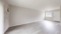 Located at Signal Pointe Circle in Sarasota, FL, this thoughtfully updated one-bedroom, one-bathroom unit offers a clean, modern aesthetic throughout its efficiently designed single-floor layout. Light wood-style vinyl flooring flows seamlessly across the entire space, complementing a neutral, softly toned color palette that enhances the sense of openness.

The living room is a standout feature, showcasing a painted concrete block accent wall that adds subtle texture and character. A sliding glass door fills the room with natural light and provides access to an outdoor view, while a wall-mounted A/C unit ensures year-round comfort.

The kitchen is well-appointed with crisp white shaker-style cabinetry, matte black hardware, a classic white subway tile backsplash, light quartz countertops, and a stainless steel sink with a modern black faucet. A large window above the counter further brightens the space.

The bedroom offers a comfortable footprint with a window overlooking the surrounding area, a wall-mounted A/C unit, and a sliding-door closet with ample storage. Clean white walls and the consistent flooring maintain the cohesive design aesthetic.

The bathroom is finished with full white subway tile surrounding a soaking tub/shower combination, accented by matte black fixtures and a natural light window — delivering a fresh, contemporary feel throughout.