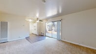 This single-floor residence in Concord, California offers a practical and comfortable layout designed for everyday living. The open living and dining area serves as the heart of the home, featuring a combination of plush carpet and wood-look vinyl flooring, a ceiling fan, and a large sliding glass door that fills the space with natural light and provides direct access to a private outdoor patio. The galley-style kitchen is efficiently arranged with white cabinetry lining both sides, offering generous storage and counter space. It is equipped with a full-size electric range, refrigerator, and a stainless steel sink beneath a frosted window. The bedrooms are generously sized, each bathed in natural light from sizable windows and finished with wall-to-wall carpet. One bedroom features a wide sliding-door closet with built-in shelving, providing excellent organization and storage capacity. The bathroom is clean and functional, appointed with wood-look flooring, a white vanity with under-sink storage, a mirror with overhead lighting, and a shower-tub combination. Neutral tones throughout the space create a bright, move-in-ready environment well-suited for a range of living arrangements.