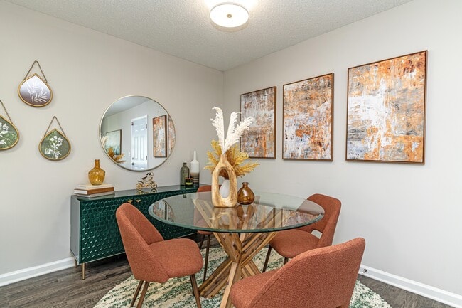 Dining area with hardwood-style flooring and overhead lighting - The Alexander Apartment Homes