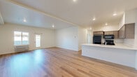 Located at 2450 1st SE in East Wenatchee, WA, this single-floor, 2-bedroom, 2-bathroom residence offers a thoughtfully designed layout with modern finishes throughout. The open-concept living and kitchen area is anchored by light-toned hardwood-style flooring that reflects natural light, creating a bright and welcoming atmosphere. The kitchen is well-equipped with an abundance of gray shaker-style cabinetry, crisp white countertops, black appliances including a refrigerator, range, microwave, and dishwasher, and a stainless steel sink — all combining for a functional and stylish space. The living area flows seamlessly from the kitchen island and features direct access to an exterior door, adding convenience and connectivity to the outdoors. Both bedrooms are carpeted and generously sized, with large windows that bring in natural light and offer exterior views. The primary bedroom includes its own en-suite bathroom featuring a dual-sink vanity with white countertops and wood-toned cabinetry. The second bathroom offers a full tub-shower combination and matching clean white finishes. A dedicated closet provides additional storage. The overall design is contemporary and neutral, presenting a clean canvas throughout.