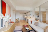 Located at 50 Western Avenue in Boston's Allston neighborhood, this thoughtfully designed one-bedroom, one-bathroom residence offers a bright and efficient single-floor layout. Light wood flooring flows throughout, creating a warm, cohesive aesthetic against crisp white walls and ceilings.

The open-plan living, dining, and kitchen area anchors the space. The kitchen features floor-to-ceiling white cabinetry, white quartz countertops, and a full suite of stainless steel appliances including a range, microwave, dishwasher, and refrigerator. A dedicated dining nook sits adjacent, maximizing the use of the open layout.

The living area is generously proportioned for the overall footprint, with large windows allowing abundant natural light and offering city views. A full-panel mirror wall further amplifies the sense of openness.

The bedroom is a well-appointed retreat, featuring a textured accent wall, a window with outdoor views, and two closets providing ample storage. The full bathroom includes a soaking tub with a tiled surround and shower. In-unit laundry adds everyday convenience.

A hallway entry with louvered closet doors provides a clean transition from the front door to the main living areas, completing this efficiently planned urban residence.