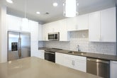 Located at 5775 Glenridge Dr NE in Sandy Springs, GA, this well-designed single-floor residence offers a thoughtfully planned layout with contemporary finishes throughout. The kitchen serves as a functional centerpiece, equipped with stainless steel appliances including a French door refrigerator, range, microwave, and dishwasher. White shaker-style cabinetry reaches to the ceiling, complemented by gray quartz countertops, a subway tile backsplash, and wood-look vinyl plank flooring that extends into the main living areas. The living area features a ceiling fan, neutral toned walls, and a set of French doors with transom windows above, allowing natural light to fill the space and providing access to an outdoor area. The bedrooms are finished with plush neutral carpet, ceiling fans, and windows with blinds that bring in soft natural light, creating comfortable and quiet retreats. The bathroom is outfitted with a white vanity, gray quartz countertop, undermount sink, and wood-look flooring, with a doorway leading directly into a spacious walk-in closet fitted with wire shelving systems. Clean lines, a neutral color palette, and modern hardware are consistent throughout, giving the entire space a cohesive, move-in-ready aesthetic suited for contemporary living.
