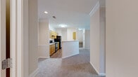 This single-story, 4-bedroom, 1-bathroom home offers a well-organized layout designed for comfortable everyday living. The open-concept kitchen and living area serve as the heart of the home, where the kitchen features warm honey-toned wood cabinetry, light countertops with a peninsula-style breakfast bar, hardwood-style flooring, and black appliances including a refrigerator, range, and dishwasher. The living room flows naturally from the kitchen, showcasing crown molding, soft neutral walls, plush carpeting, and a door with an adjacent window that opens to an outdoor space with natural light.

The four bedrooms are carpeted and finished with warm beige tones, each equipped with ceiling fans. The generously sized primary bedroom offers ample room for a full furniture arrangement. Several bedrooms feature access to closet space, with two dedicated closets throughout the home providing practical storage solutions.

The bathroom includes a wood-toned vanity with a light countertop, a tiled shower, and hardwood-style flooring. A dedicated laundry room with washer and dryer hookups and wood-style flooring adds in-unit convenience. Throughout the home, consistent neutral paint tones, white trim, and recessed and flush-mount lighting create a clean, cohesive aesthetic.