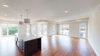 Located at 2810 W 43rd St in Minneapolis, Minnesota, this single-floor residence offers a thoughtfully designed open-concept layout that seamlessly connects the kitchen, dining, and living areas. Rich hardwood flooring flows throughout the main living spaces, complemented by recessed lighting and an abundance of natural light streaming through large windows and glass doors that open to outdoor balconies with neighborhood views.

The gourmet kitchen is a standout feature, showcasing floor-to-ceiling dark espresso cabinetry, light quartz countertops, a subway tile backsplash, a professional-grade stainless steel range with a wall-mounted hood, and a stainless steel refrigerator. A substantial center island with built-in shelving and pendant lighting anchors the space, making it ideal for both cooking and entertaining.

The living and dining areas are generously proportioned, with multiple sets of glass doors providing direct access to the balcony and flooding the interior with natural light. Bedrooms feature plush carpeting and large windows with tree-lined street views. The walk-in closet is outfitted with a comprehensive custom organization system including shelving, hanging rods, and built-in drawers.

The bathroom is finished with tile flooring, a dark-framed vanity mirror, quartz countertops, and chrome fixtures. A dedicated laundry room with a side-by-side washer and dryer and overhead cabinetry adds everyday convenience to this well-appointed residence.