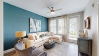 Located at 2175 Easton Loop in Kissimmee, FL, this thoughtfully designed one-bedroom, one-bathroom residence offers a well-appointed single-floor layout with a cohesive coastal aesthetic and modern finishes throughout. Light wood-style flooring flows seamlessly across all living areas, anchoring the warm and inviting atmosphere.

The kitchen is a standout feature, showcasing gray shaker-style cabinetry, white subway tile backsplash, stainless steel appliances, and a central island with seating — ideal for both meal preparation and casual dining. Pendant lighting adds a refined touch overhead, while recessed lighting ensures the space remains bright and functional.

The living room is defined by a bold teal accent wall, large windows with sheer drapery, and a glass door that allows abundant natural light to fill the room while offering views of the outdoors. The bedroom continues the coastal theme with a matching teal accent wall, warm wood-toned furnishings, and dual windows overlooking lush greenery.

The bathroom is clean and contemporary, featuring a gray vanity with white countertop, a large mirror, modern fixtures, and a full tub-shower combination with tiled surround. A dedicated closet provides practical storage. Every room reflects a consistent, well-curated design sensibility that balances comfort with style.