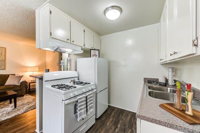 Specious open concept kitchen with appliances and plank flooring at the Promenade Apartment in Van Nuys, CA - The Promenade