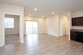 This single-floor residence offers a clean, modern design with a thoughtful layout spread across multiple rooms. The open-concept living and kitchen area serves as the heart of the home, featuring light wood-look luxury vinyl plank flooring, recessed lighting, and a sliding glass door that fills the space with natural light and provides outdoor access.

The kitchen is well-equipped with rich dark espresso cabinetry, granite-look countertops, and a full suite of black appliances including a range, microwave, dishwasher, and refrigerator. Generous upper and lower cabinet storage makes the kitchen highly functional.

The bedrooms are carpeted for comfort and feature neutral wall tones, windows with blinds for natural light and privacy, and closets — including a sliding-door closet in one room. A ceiling fan is present in the primary bedroom, adding to the comfort of the space.

The bathrooms are finished consistently with the kitchen, featuring matching dark cabinetry, granite-look countertops, and single-basin vanities with large mirrors. One bathroom includes a shower/tub combo, while another features a more open vanity layout. Light wood-look flooring runs throughout the bathrooms, complementing the overall design aesthetic. The space presents a cohesive, move-in-ready feel throughout.